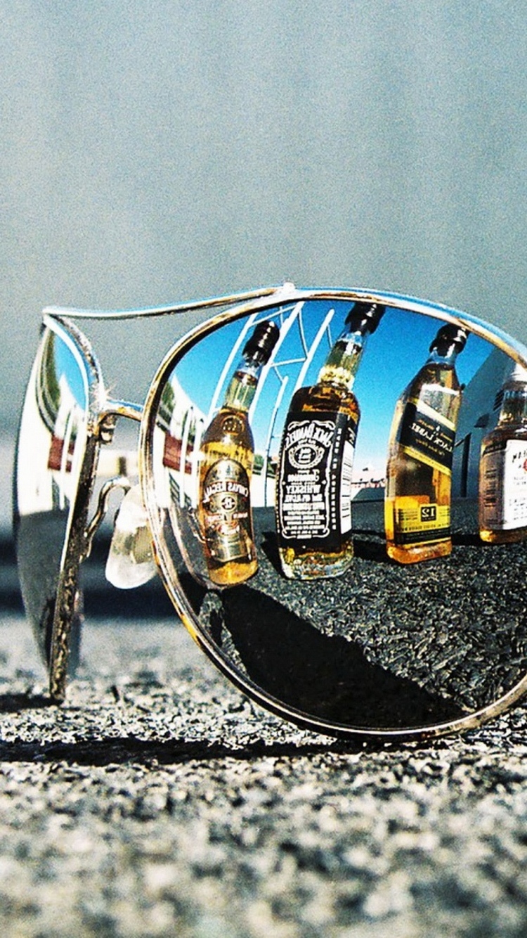 太阳镜反射的威士忌瓶