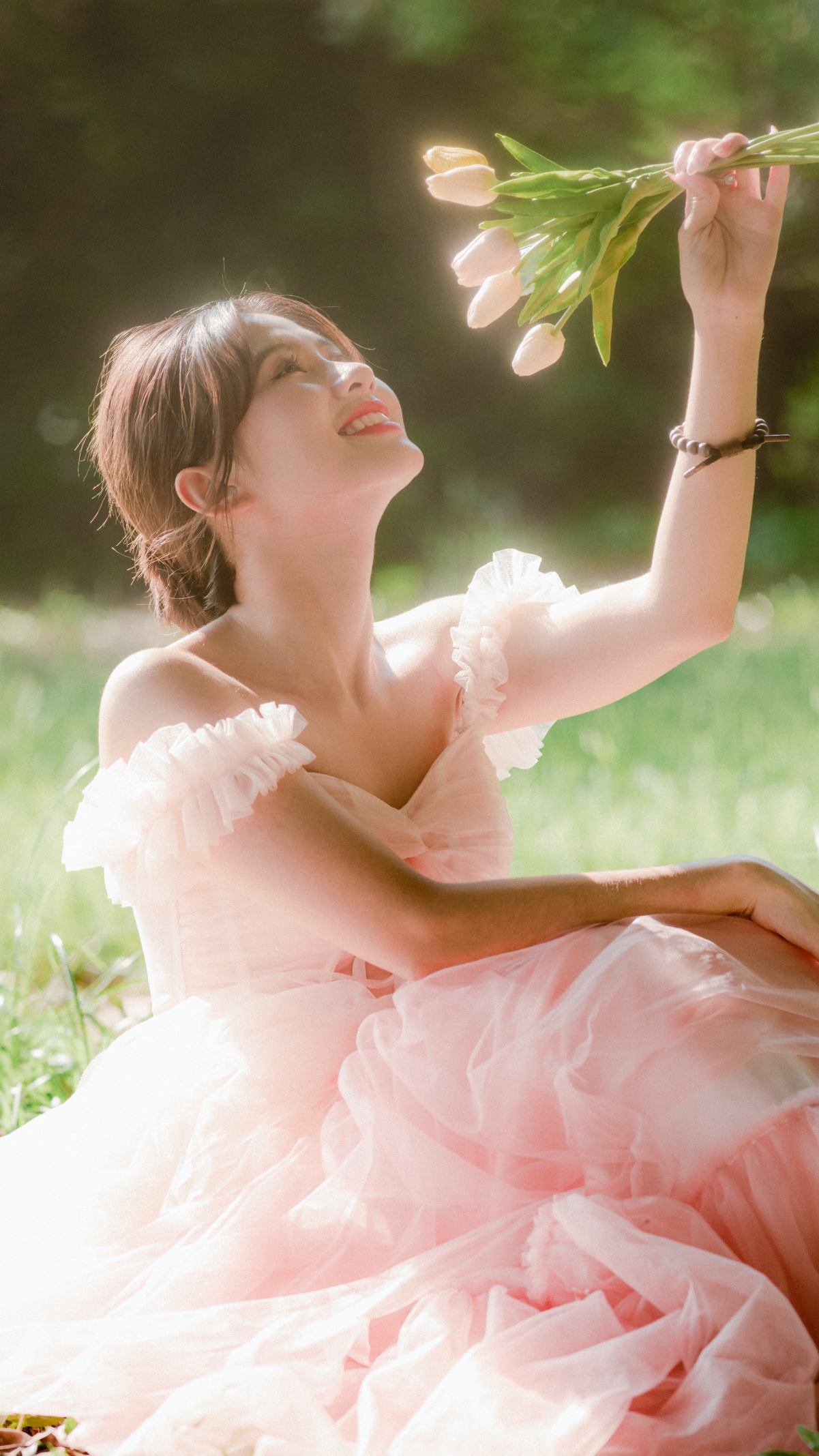 女神节快乐 森林 坐在草地上的美女 粉色裙子 鲜花 微笑 4k手机壁纸